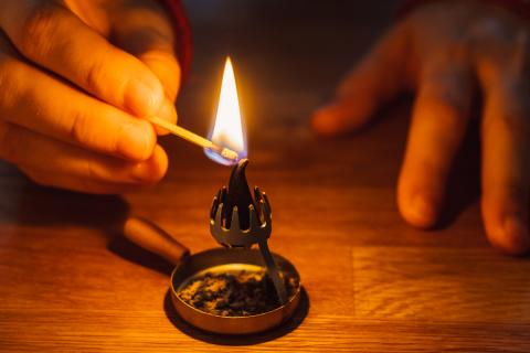 Man lighting an incense burner at Christmas by Jonathan Schoeps | Lightstock | Used by Permission.